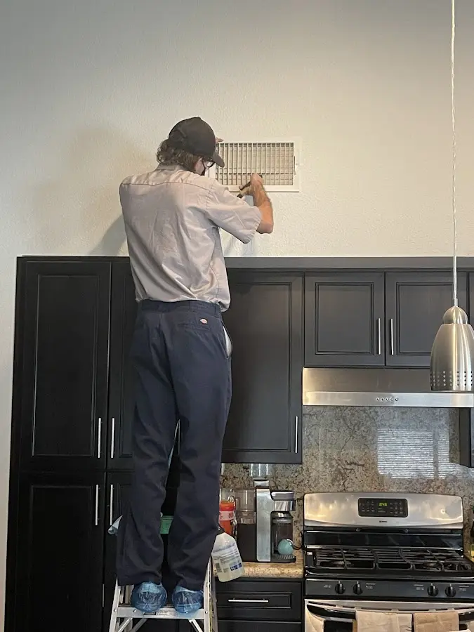 Technician inspecting an air vent during HVAC service in Brookville